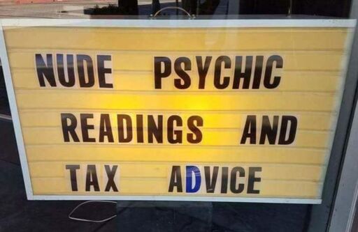 A large sign in a window advertises "NUDE PSYCHIC READINGS AND TAX ADVICE". The "D" is blue, where as all the other letters are black.