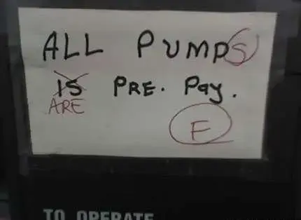 Sign on gas station pump reads "All Pump is pre. pay." It has been marked with red pen to correct mistakes such as adding an "s" to Pump and scratching out "Is" to replace with "are" and then grading it F.